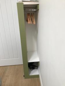 a closet with a green shelf next to a wall at The Nook at Claremont House CA12 4LT in Keswick