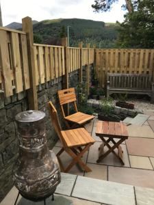 a patio with a chair and a table and a vase at The Nook at Claremont House CA12 4LT in Keswick