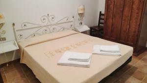 a bedroom with a white bed with towels on it at Residence Spiaggia Bianca in Golfo Aranci