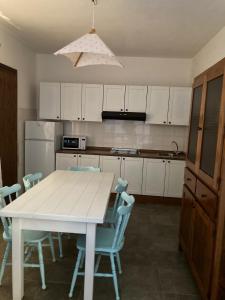 a kitchen with a white table and blue chairs at Residence Spiaggia Bianca in Golfo Aranci