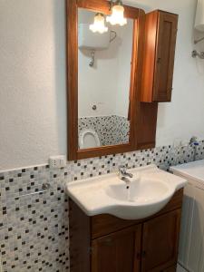 bagno con lavandino e specchio di Residence Spiaggia Bianca a Golfo Aranci