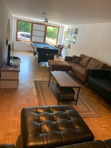 a living room with a couch and a pool table at Maison de Rochehaut in Rochehaut