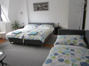 1 dormitorio con 2 camas y 1 silla en Kántor Vendégház, en Zalaegerszeg