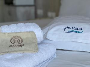 uma pilha de toalhas sentadas em cima de uma cama em VANA Studios & Apartments em Limenaria