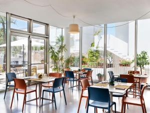 a restaurant with tables and chairs and windows at Hotel Colle Del Sole in Alberobello