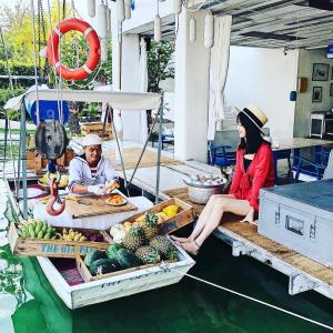 um homem e uma mulher sentados num barco com frutas e legumes em The Oia Pai Resort em Pai