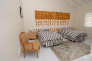 a bedroom with two beds and a desk and a chair at Zamaca' Bed and Breakfast in Micoud
