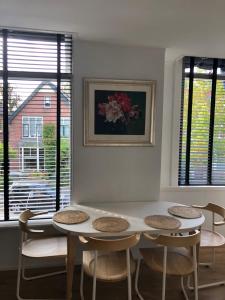 a table and chairs in a room with windows at Thomasloft in Oegstgeest