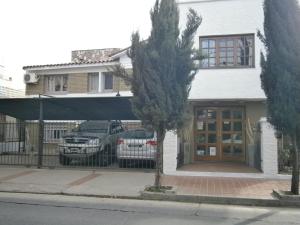 una casa con dos coches estacionados frente a ella en Hotel Lihuel en Villa Carlos Paz