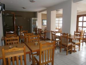 ein Esszimmer mit Holztischen und Stühlen in der Unterkunft Hotel Lihuel in Villa Carlos Paz