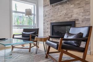 a living room with two chairs and a fireplace at Contemporary Luxury 4 bedroom House near Downtown in Calgary