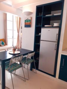 a kitchen with a table and a refrigerator at App Rosanna, Estoril Beach, 2steps from the sea, Free Wi-Fi & AC in Sal Rei