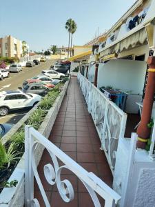 einen Gehweg mit einem weißen Geländer neben einem Parkplatz in der Unterkunft Guanche Bay in Santa Cruz de Tenerife