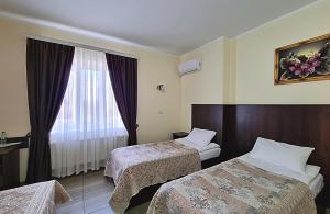 een hotelkamer met 2 bedden en een raam bij Готель "Валерія" in Novoselytsya