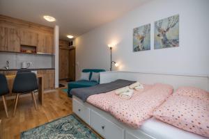 a small bedroom with a bed and a kitchen at Studio apartman Anja in Zlatibor