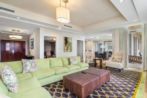 sala de estar con sofá verde y mesa en Presidential Penthouse Suite, en Riviera Beach