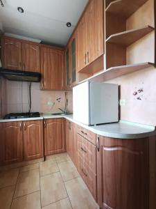 una cucina con armadi in legno e frigorifero bianco di Lavina mall apartments 4 a Sumy