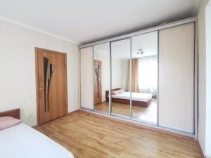 a bedroom with a large glass door and a bed at Lavina mall apartments 4 in Sumy