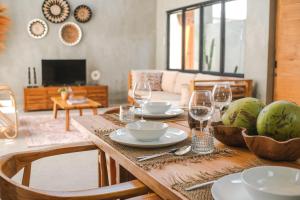 Una mesa de madera con platos y copas de vino encima. en Villa Kamal Umalas, en Kerobokan