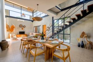 Un comedor con una larga mesa de madera y sillas. en Villa Kamal Umalas, en Kerobokan