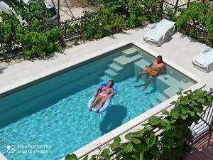two people swimming in a swimming pool at Apartments Gina in Trogir