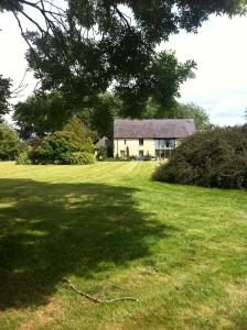 uma casa no meio de um campo verde em Farm Stay -Nr Silverstone, Bicester Village and Stowe em Hinton in the Hedges