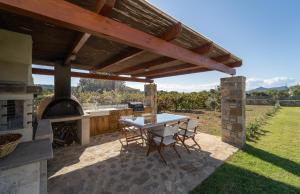 un patio con una mesa y una parrilla al aire libre en CARLOS MANSION LUXURY SUITES, en Methoni