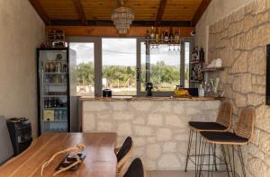 een keuken met een houten tafel en een stenen muur bij CARLOS MANSION LUXURY SUITES in Methoni