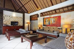 ein Wohnzimmer mit zwei Sofas und einem Fernseher in der Unterkunft The Maya Seminyak Villas in Seminyak
