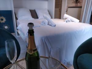 een fles wijn op een tafel naast een bed bij Le charme du centre YourHostHelper in Épernay