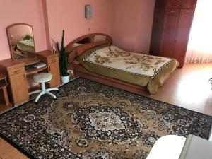 Schlafzimmer mit einem Bett, einem Spiegel und einem Teppich in der Unterkunft Апартаменти з окремою ванною кімнатою in Czernowitz
