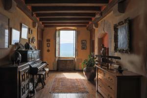 a living room with a piano and a large window at Château de Sothonod in Sothonod