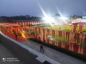 a group of people walking around a building with lights at Aashirwad Garden & Resort in Pilani