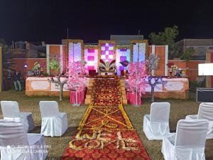 a long table with chairs and flowers on it at Aashirwad Garden & Resort in Pilani