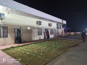 a building with green lights on the grass in front at Aashirwad Garden & Resort in Pilani +6 photos