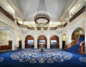 a large lobby with a chandelier and blue carpet at Fairmont Château Lake Louise in Lake Louise +37 photos