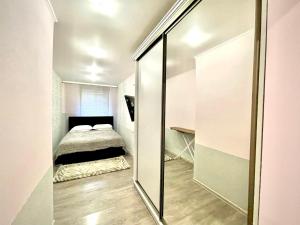 - une petite chambre avec un lit et un miroir dans l'établissement Kvitka Polonyny Apartamenty, à Solochyn