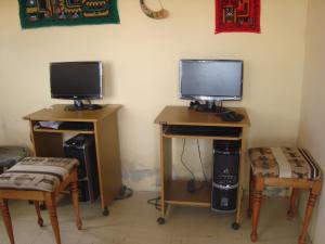 Habitación con 2 escritorios, 2 monitores y 2 sillas. en IMPERIO del SOL en Comunidad Yumani
