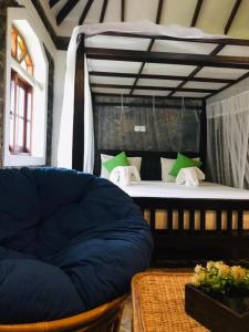 a bedroom with a bed and a couch in a room at Serenity Beach Cabanas in Tangalle