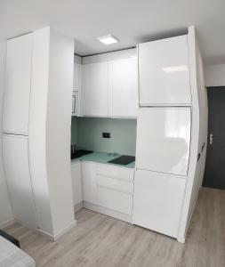 - une cuisine blanche avec des placards blancs et un réfrigérateur dans l'établissement Torre Saltillo, à Torremolinos