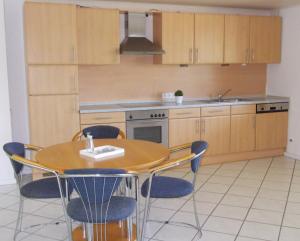 - une cuisine avec une table, des chaises et un évier dans l'établissement Ferienwohnung Knobloch, à Wahlheim