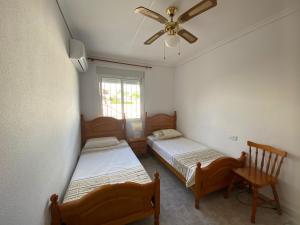Un dormitorio con dos camas y un ventilador de techo. en Large villa perfect for families, en Los Alcázares