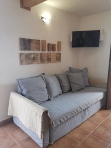 a couch in a living room with a flat screen tv at Casa Rural Leo: remanso de paz y tranquilidad in Agulo