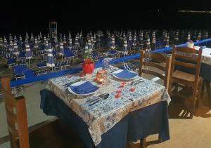 a table with a blue and white table cloth and chairs at Ahm7nani in Mascali