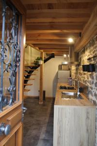 uma cozinha com um balcão com um lavatório e uma escadaria em Gîte du moulin em Chénelette