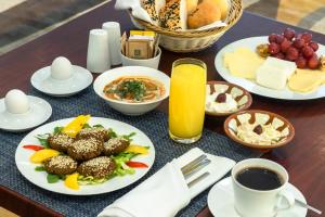 una mesa con platos de comida y tazas de café en Holiday Inn Yanbu, an IHG Hotel en Yanbu