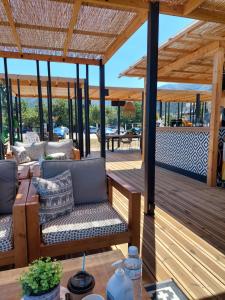 a wooden deck with couches and a table at Mare Beach Apartments in Stavros