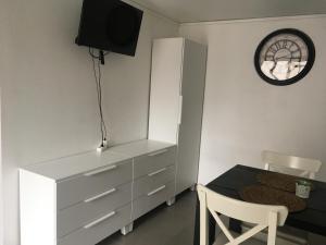 une chambre avec une table, une commode et une horloge dans l'établissement Lolita place, à Obernai