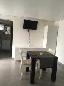 une salle à manger avec une table noire et des chaises blanches dans l'établissement Lolita place, à Obernai 6 autres photos