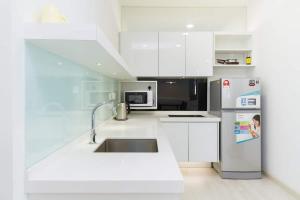 a white kitchen with a sink and a refrigerator at Deluxe and Feel like a home 1, 3-6 pax ,Netflix, Georgetown in George Town